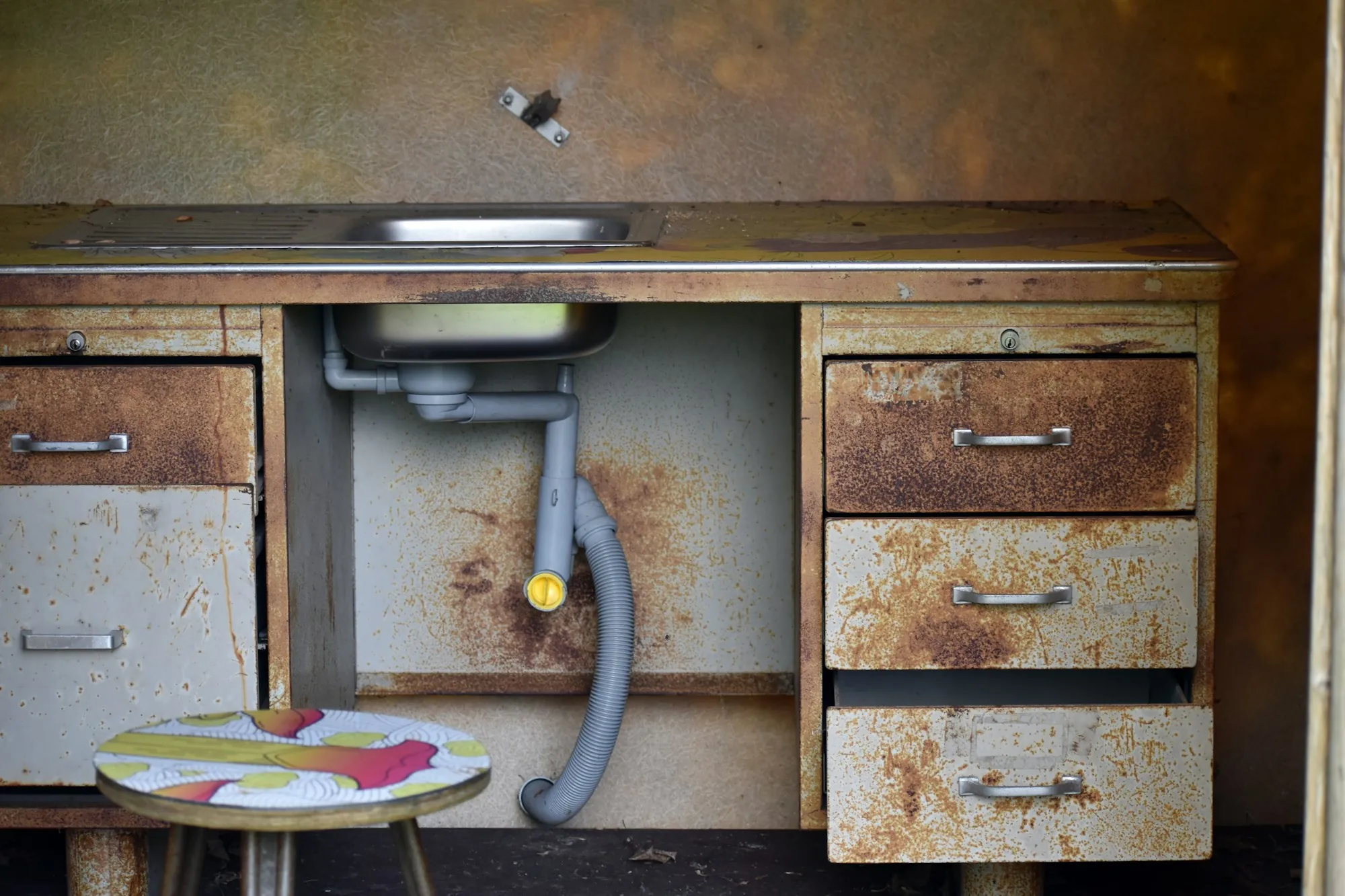 Under-Sink Drinking Water Filters in Newport Beach Open sink cabinet showing the drain and supply plumbing