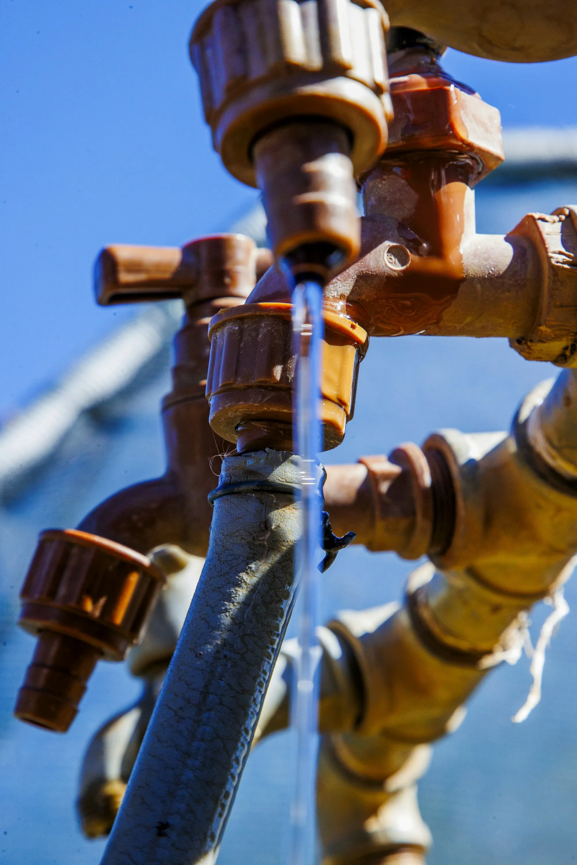 Why Newport Beach Homeowners Trust This Crew Water flowing from newly fitted pipes against a blue sky